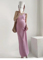 Load image into Gallery viewer, A pregnant woman wearing a pink waffle-knit sleeveless maxi dress, holding a white Gucci-branded cup to her face and carrying a woven straw bag, set against a minimalist white studio background.
