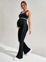 Load image into Gallery viewer, Woman wearing a black and white jumpsuit on a plain background
