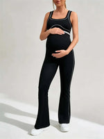 Load image into Gallery viewer, Person wearing a black maternity outfit with white trim on a light background
