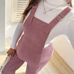 Load image into Gallery viewer, Person wearing pink overalls sitting on a couch indoors
