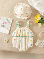Load image into Gallery viewer, Baby romper with colorful heart patterns on a beige surface with flowers and a card.
