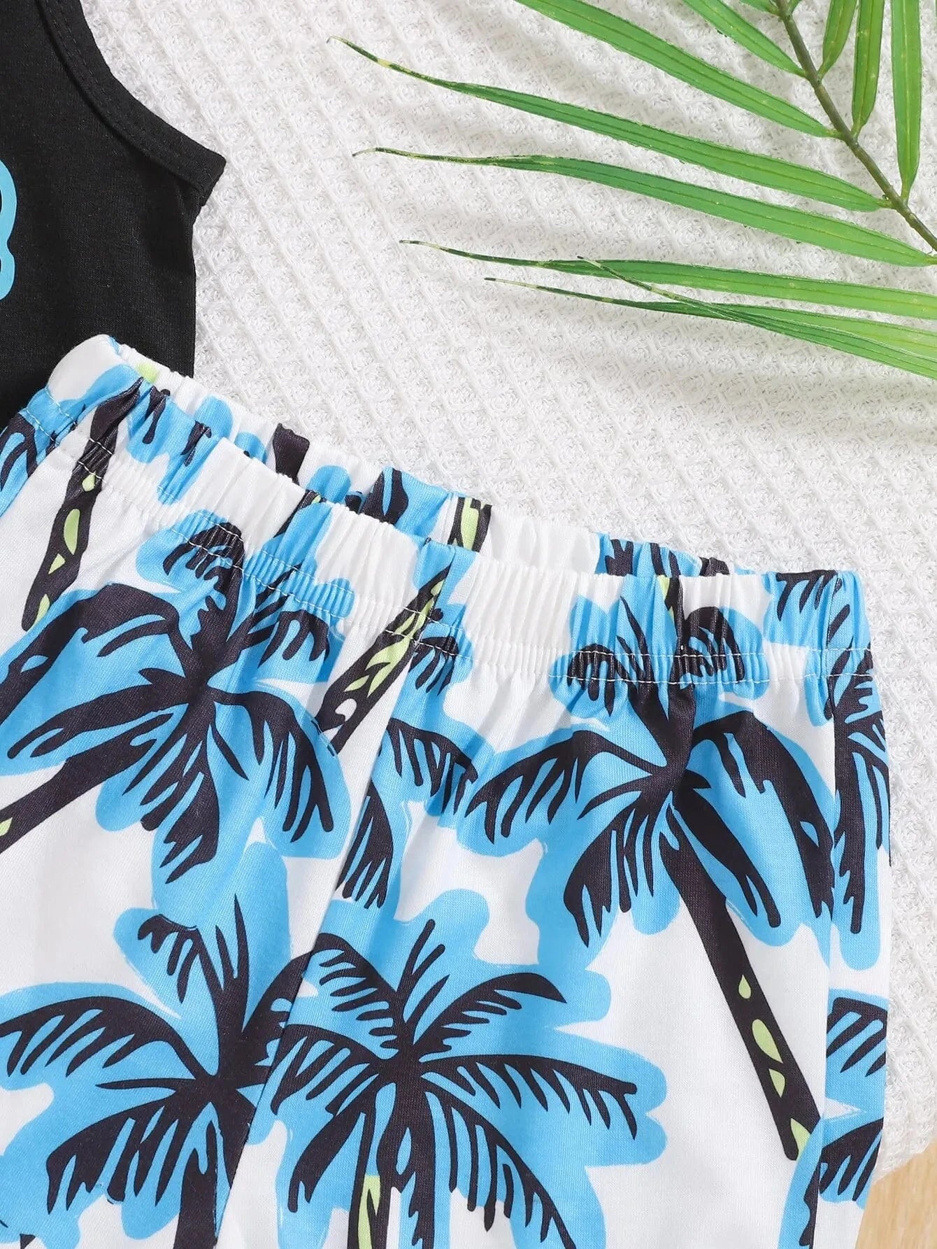 Close-up of swim shorts with palm tree pattern on a white background