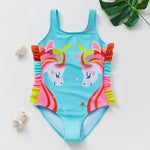 Load image into Gallery viewer, Colorful unicorn-themed swimsuit on a white background with green leaves.
