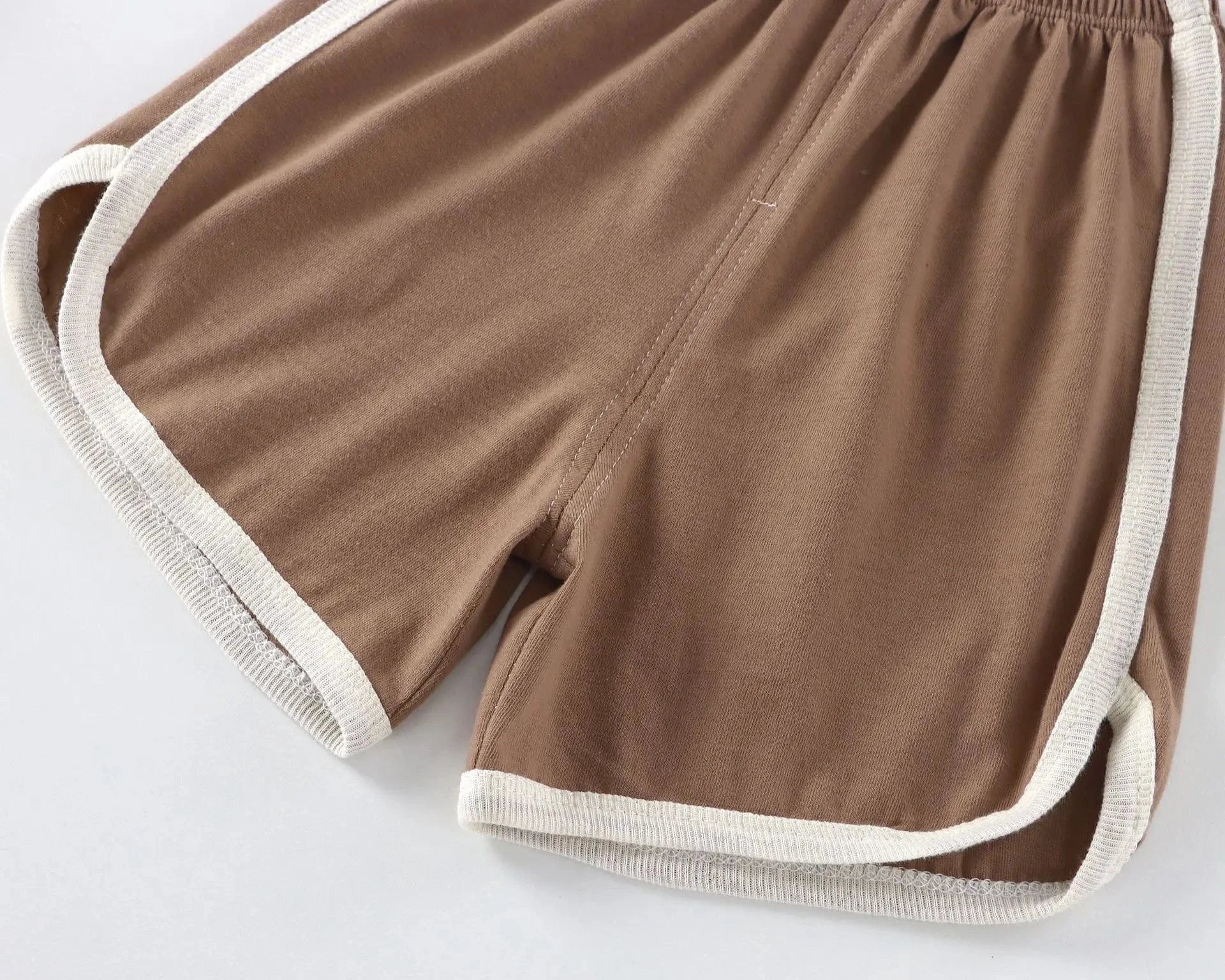 Brown shorts with white trim on a light gray background