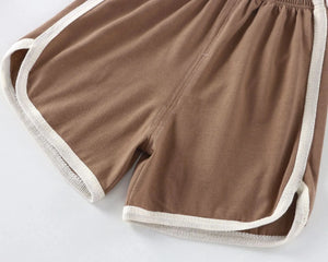 Brown shorts with white trim on a light gray background