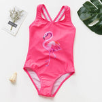 Load image into Gallery viewer, Pink swimsuit with flamingo design on a white surface with decorative elements.
